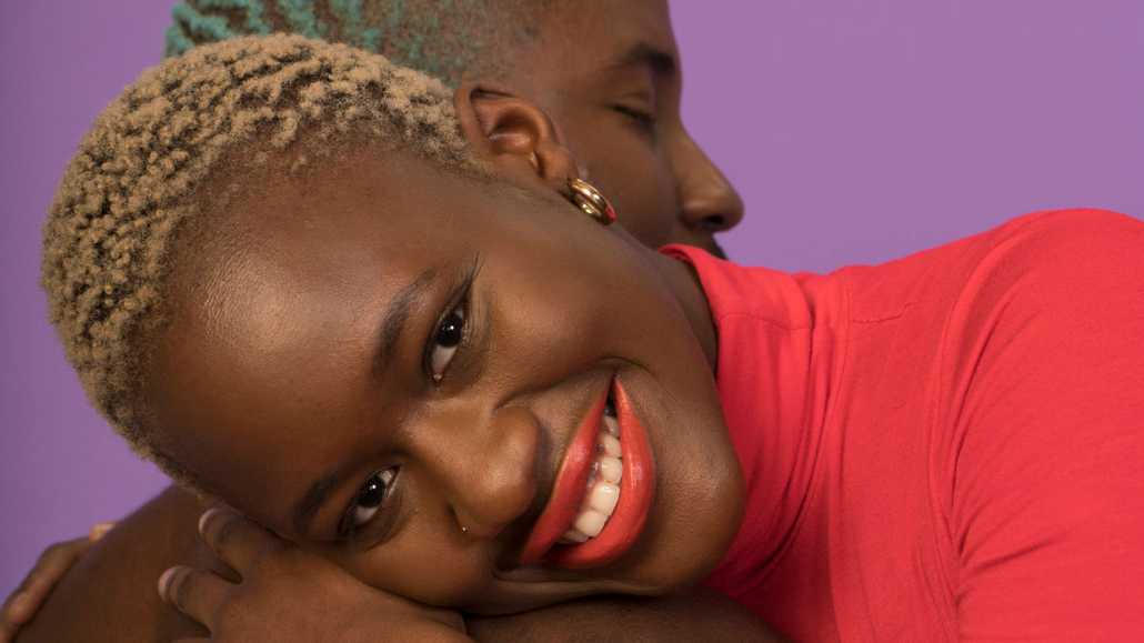 Young african woman smiling and hugging her boyfriend