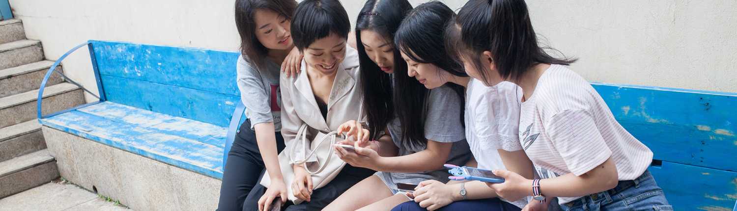 Five young Chinese women using social media